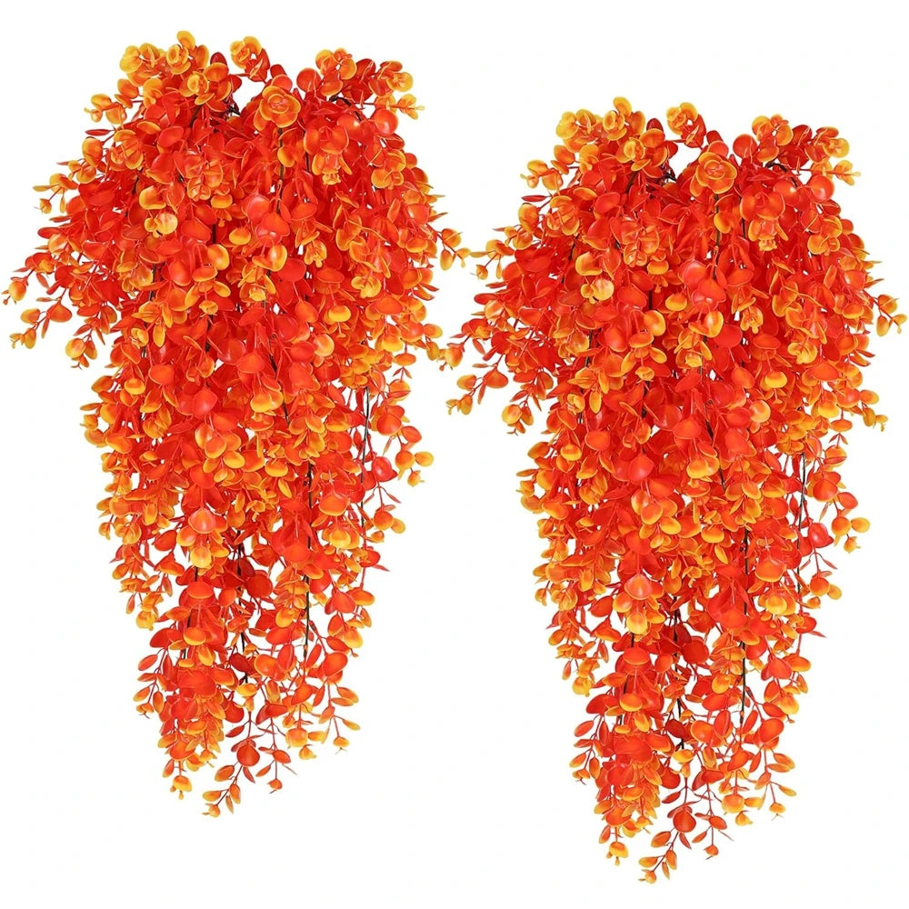 Two strands of bright orange artificial eucalyptus leaves used for home decor