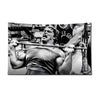 A muscular man lifts weights in a gym setting.