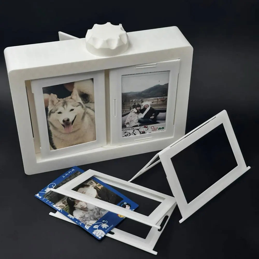 A white rotating flip photocard display frame with two viewing windows and a decorative top