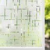 Frosted window privacy film with a light green tint and a geometric pattern applied to glass.