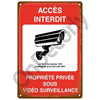 Red metal sign warning that access is forbidden and the property is under video surveillance.