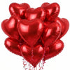 A bunch of shiny red heart-shaped foil balloons tied together.