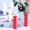 A set of red and white heart-shaped silicone candle molds displayed on a white surface.