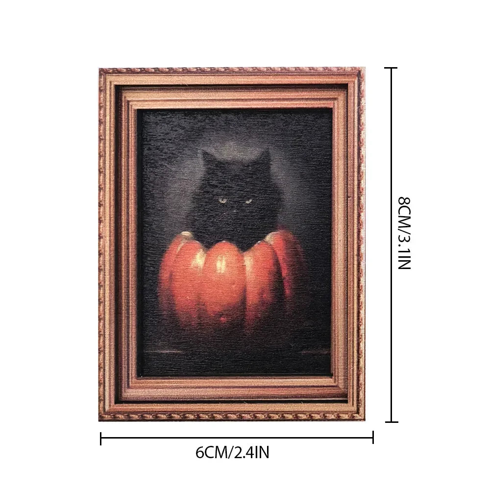 A framed artwork featuring a black cat silhouette against a dark background with orange pumpkins.