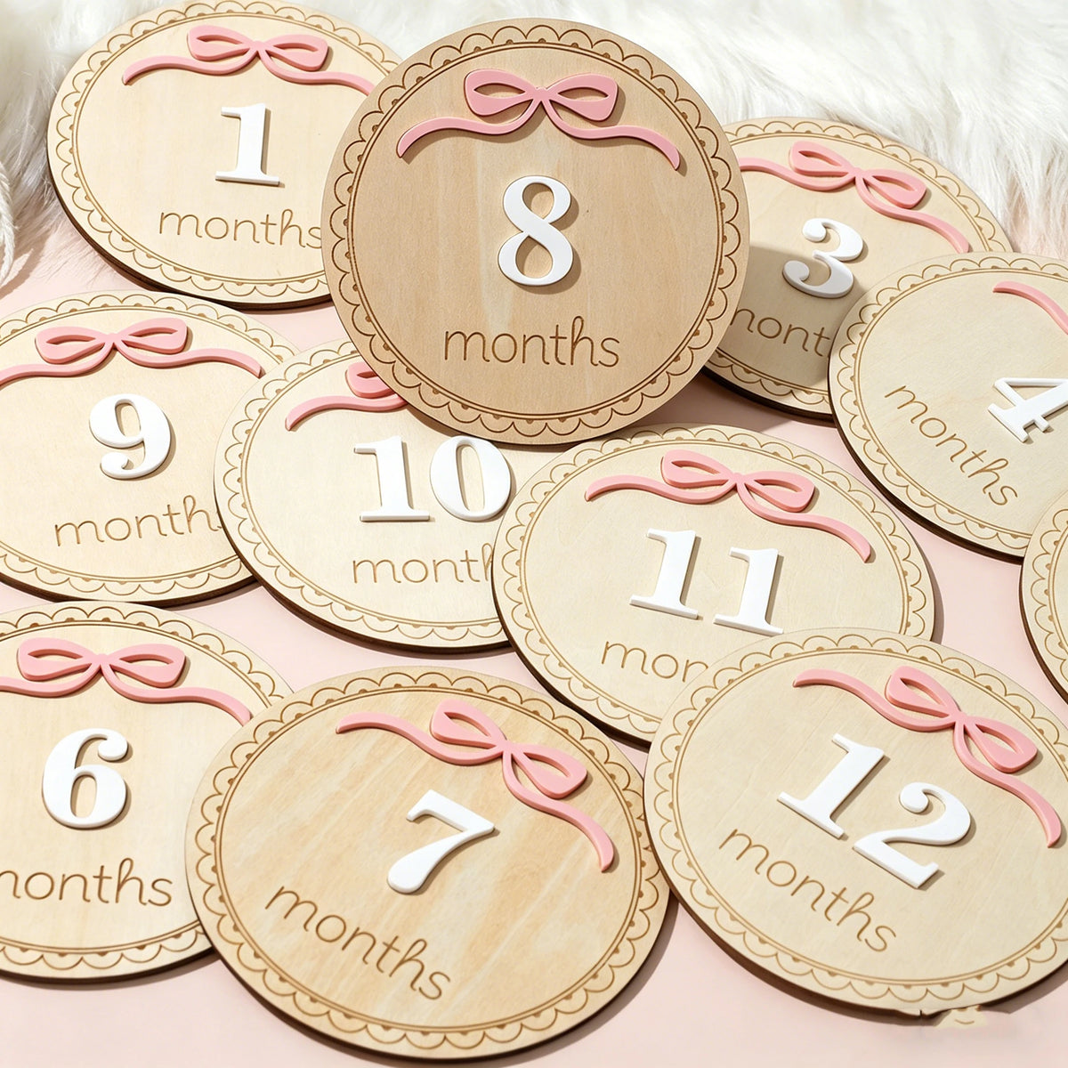 A set of wooden baby milestone cards showing numbers 1 through 12 for monthly photo props
