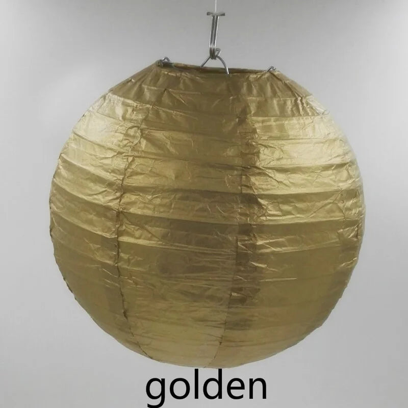 A large, round golden paper lantern suspended by a wire.