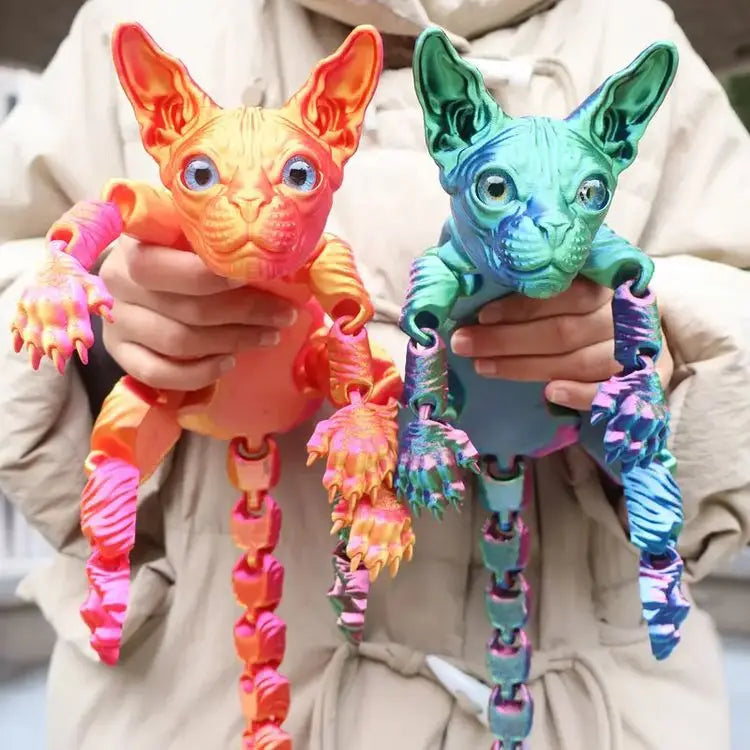 A person holds two realistic skin-toned cats, one orange and one teal, made of fidget toy material.