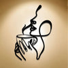 A black line art sculpture of a hand holding a cup, with a stylized face emerging from the cup.