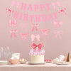 A pink glitter bow birthday banner hangs above a cake decorated for a birthday celebration.