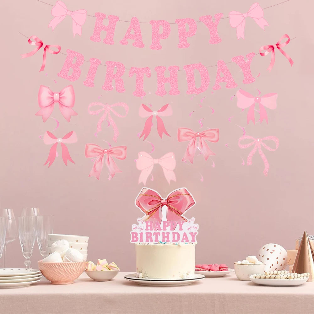 A pink glitter bow birthday banner hangs above a cake decorated for a birthday celebration.