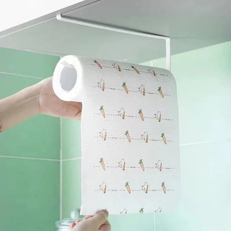 A roll of white paper with small carrot illustrations is being held against a light green tiled wall.