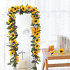 A vertical garland of silk yellow sunflowers and green leaves used for home decor or weddings.