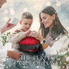 A woman and a boy are presenting a red rose bouquet in a heart-shaped gift box as the perfect gift of love.
