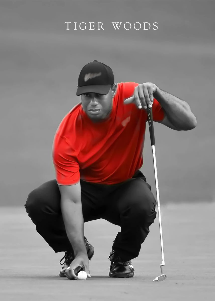 Black and white photo of Tiger Woods in a red shirt crouching on a golf course.