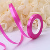 Pink satin ribbon roll with the number 10 is displayed among white flowers.