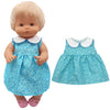 A blonde doll wearing a light blue polka dot dress with a white collar and a matching skirt.