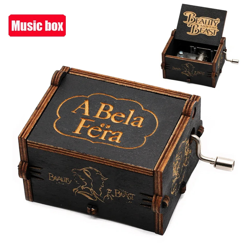 A carved wooden music box with a lid engraved A Bela Féra and a separate box featuring the Beauty Beast theme.