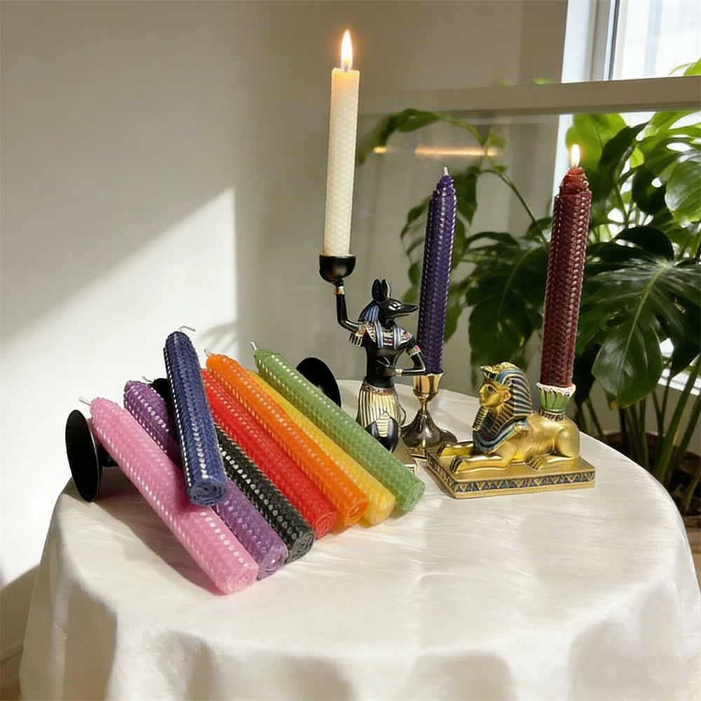 A display of colorful honeycomb beeswax candles and a decorative figurine on a white tablecloth.