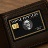A brown leather wallet features a black and gold credit card sticker with the text White Privilege Exclusive