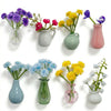 A collection of mini ceramic plant vases in various shades of purple, pink, and green.