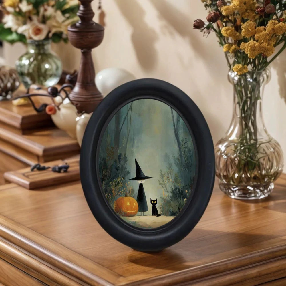 Oval wall art featuring a witch silhouette and a black cat in a misty woodland scene.