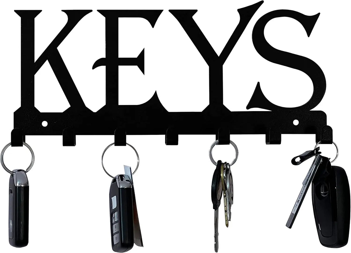Black decorative metal wall-mounted key holder with seven hooks and various keys.
