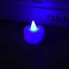 A glowing blue heart-shaped flameless LED tealight candle resting on a dark wooden surface.