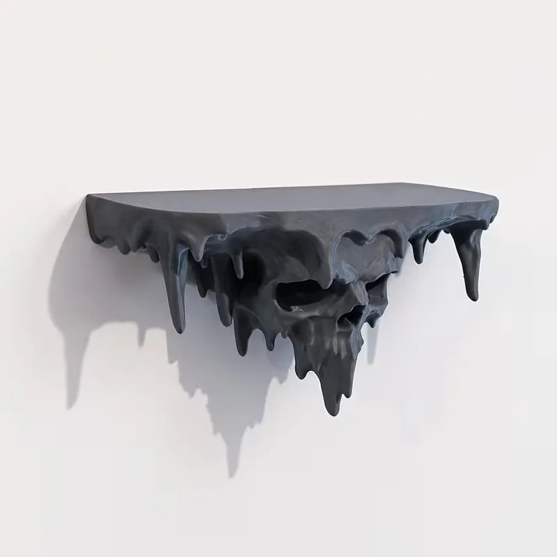 A dark, melted skull wall shelf with dripping edges, displayed against a white background.