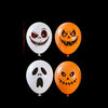 Two latex balloons, one white and one orange, featuring spooky, grinning jack-o'-lantern faces.