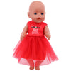 A baby doll with light skin and blue eyes wearing a red Christmas outfit set.