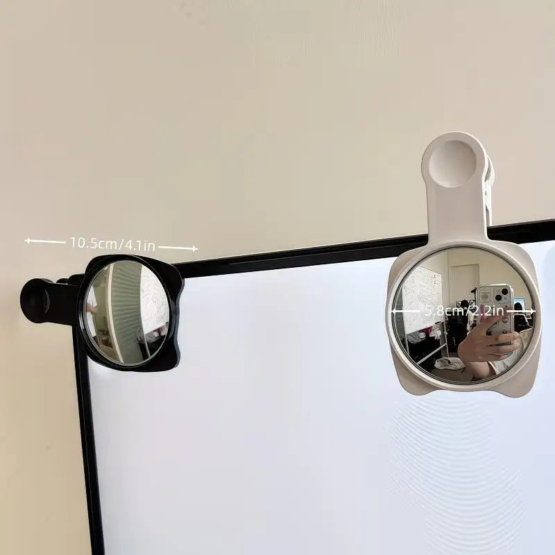 A convex mirror mounted on a stand, showing a reflection of the user's hand and surrounding area.