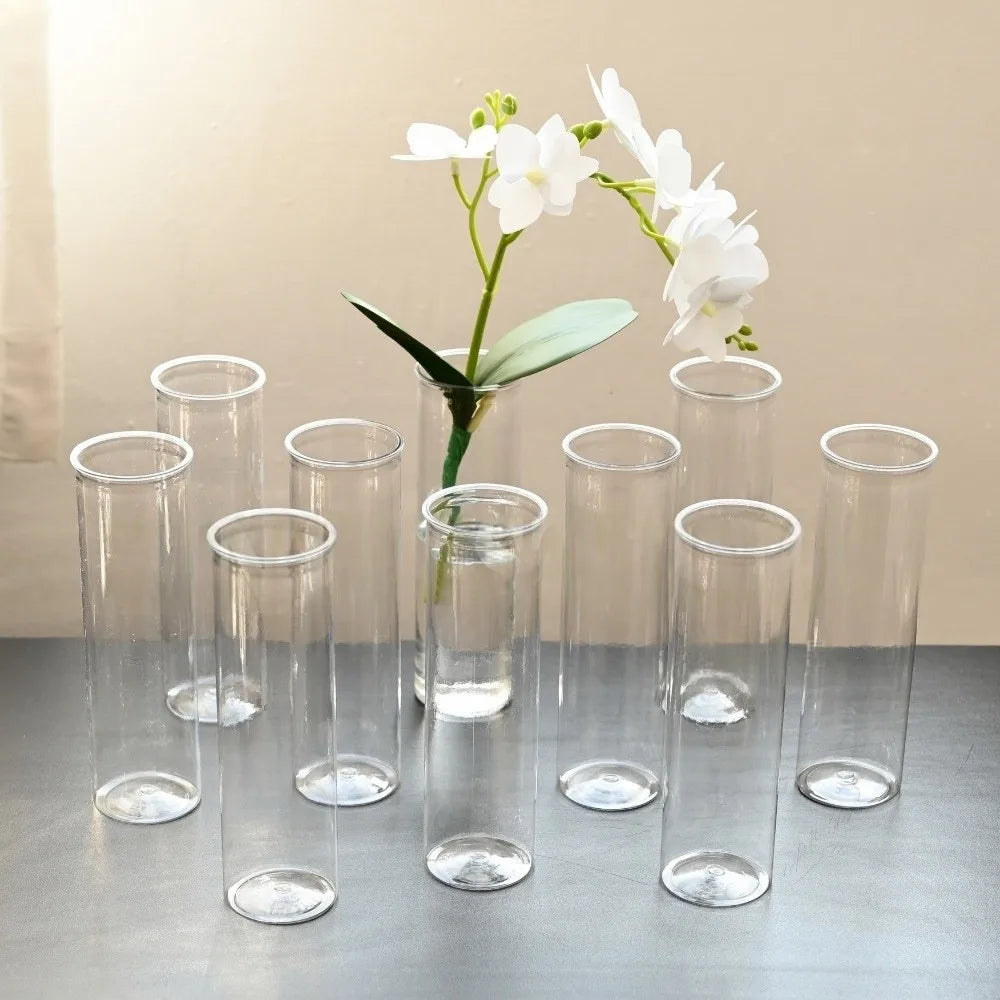 A collection of crystal clear cylinder glass vases with white flowers and green leaves