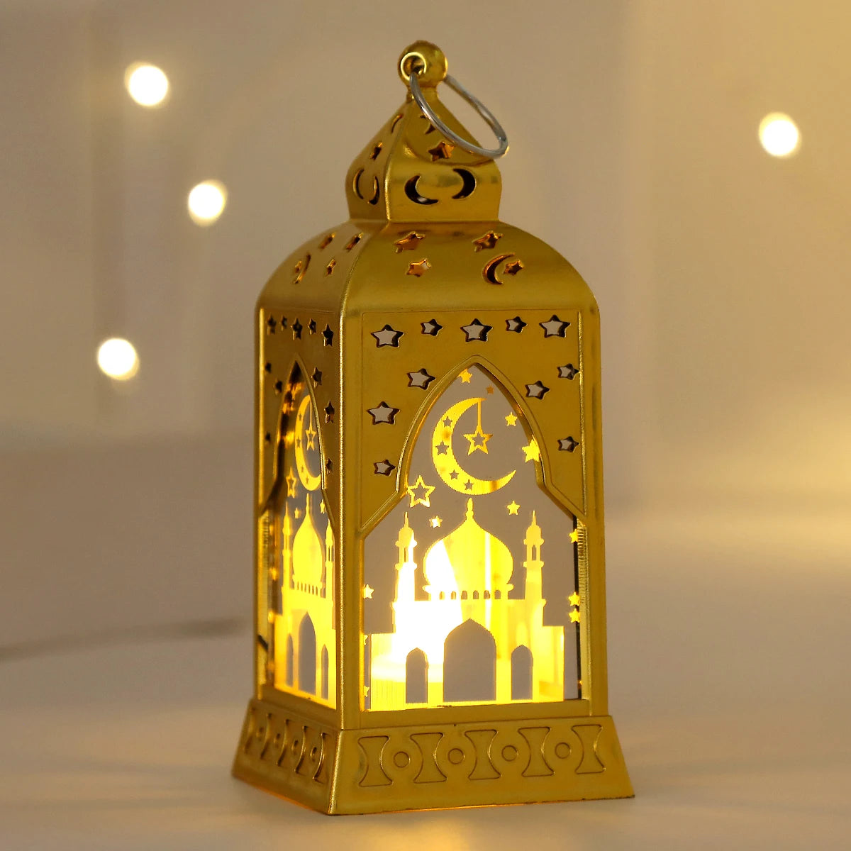 A golden LED lantern shaped like a mosque with stars and a crescent moon, illuminated from within.