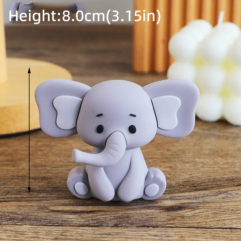 A small, gray cartoon elephant figure sitting on a wooden surface.