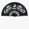 Black traditional bamboo folding fan featuring yin-yang symbols and dragons for martial arts