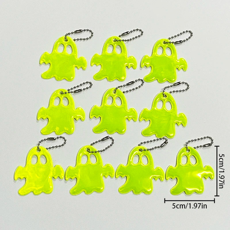 A set of bright neon yellow ghost-shaped reflective keychains on a white background.