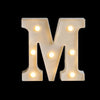 A large, illuminated letter M made of warm white LED alphabet light against a black background.