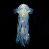 A translucent blue and purple jellyfish lantern hanging against a black background.