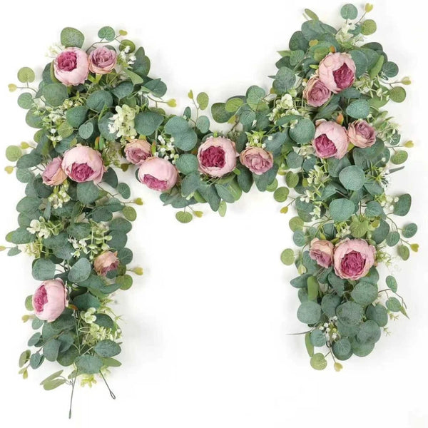 Artificial peony roses and eucalyptus leaves arranged in a decorative garland