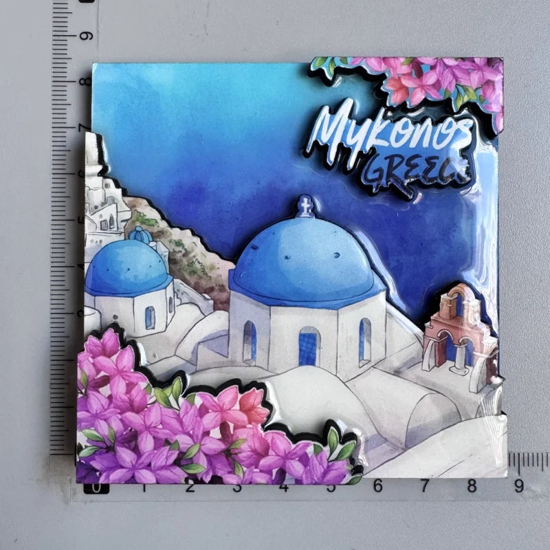 A set of wooden fridge magnets featuring a stylized view of Mykonos, Greece, including domes and pink flowers.