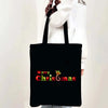 Black tote bag with red text reading Merry Christmas and a festive holiday design