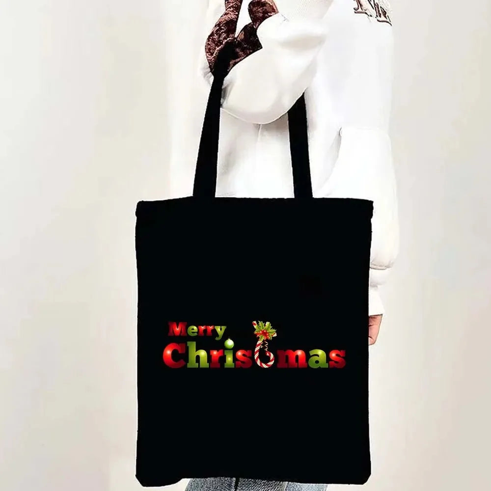 Black tote bag with red text reading Merry Christmas and a festive holiday design