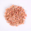 A pile of small, peach-colored silk artificial flower heads used for weddings and crafts.
