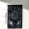 Black sun and moon boho wall tapestry hanging on a white wall