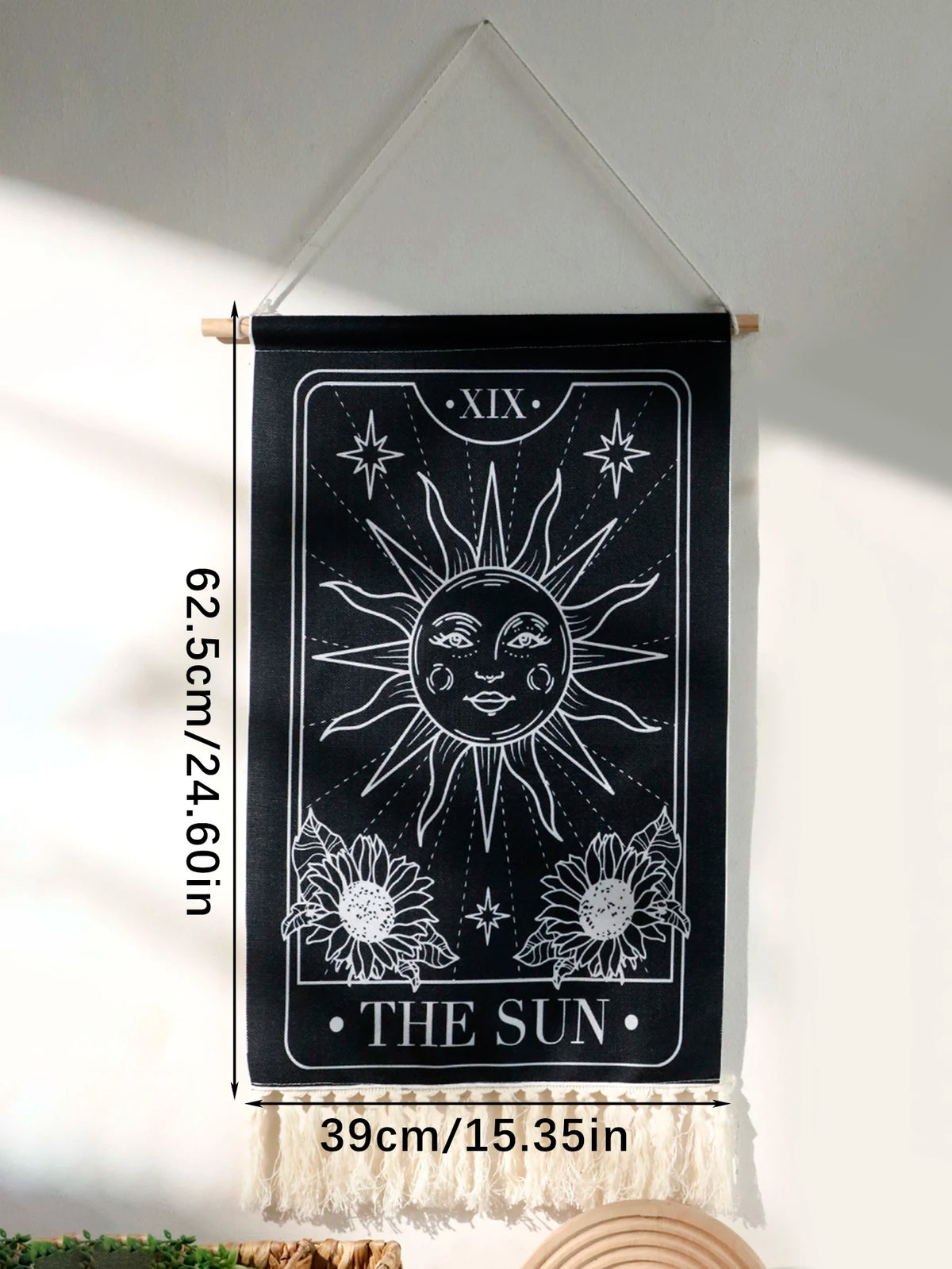 Black sun and moon boho wall tapestry hanging on a white wall