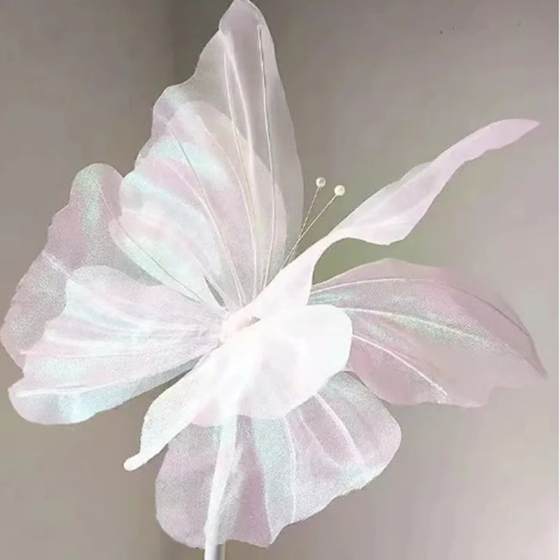 A delicate, translucent pink and white silk artificial butterfly decoration with light iridescent wings.