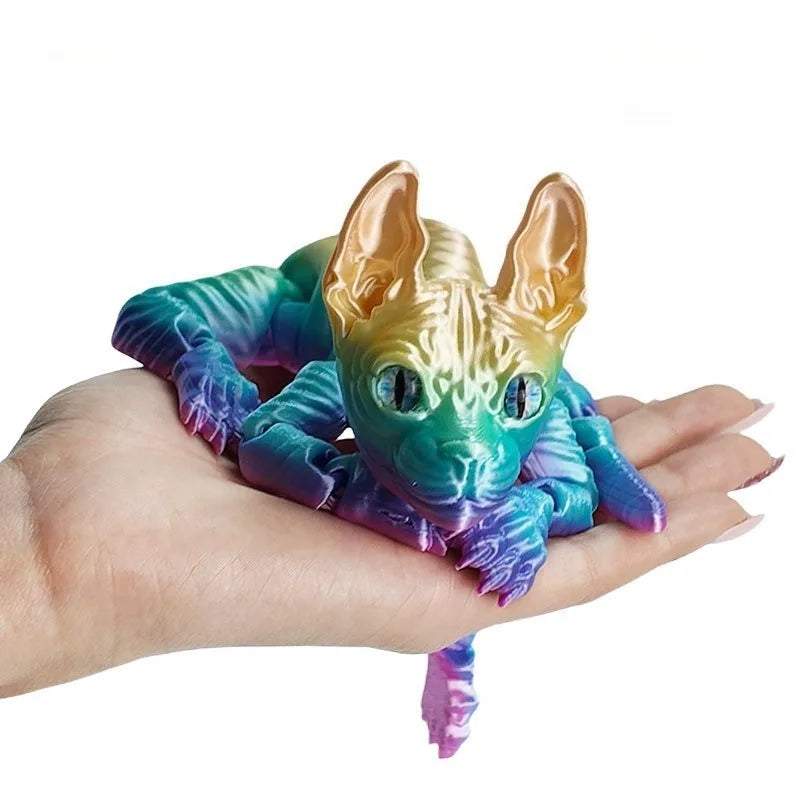 A hand holds a gold and teal articulated sphynx cat figurine with large ears.