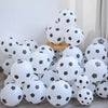 A collection of white and black oval latex football party balloons arranged on a surface.