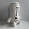 A soft plush toy shaped like an energy drink can, white with black text and a striped design.
