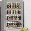 A magnetic spice rack for a refrigerator displaying various spices and herbs in glass jars.